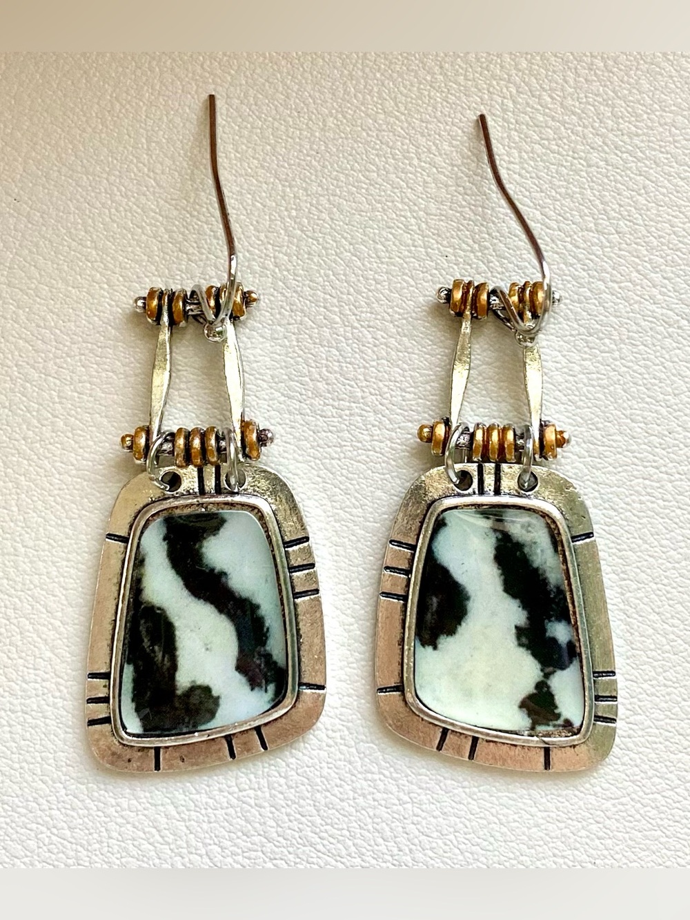 Black and white cow print earrings with silver and gold accents